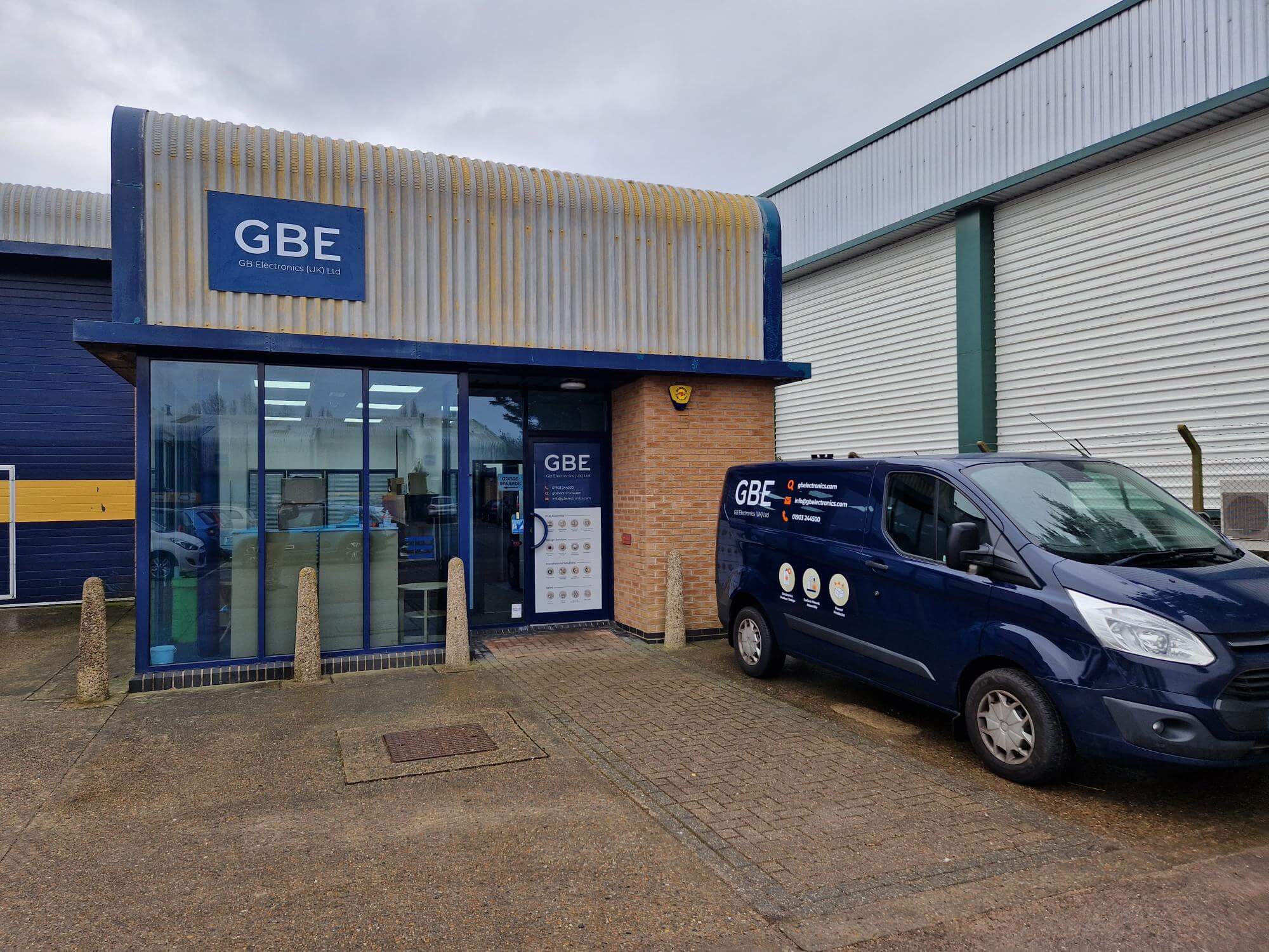 An external view of GB Electronics' new site in Littlehampton. The unit has GBE signs on the outside and there is a blue GBE van parked in front.